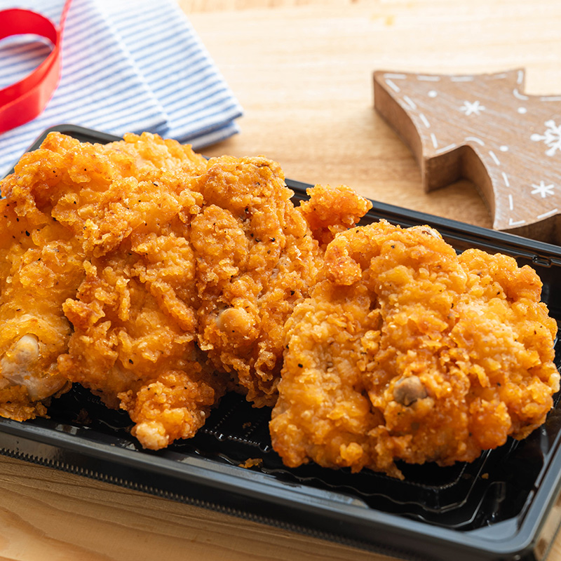 Knuspriges Fried Chicken auf schwarzer Schale als typisches japanisches Weihnachtsessen.