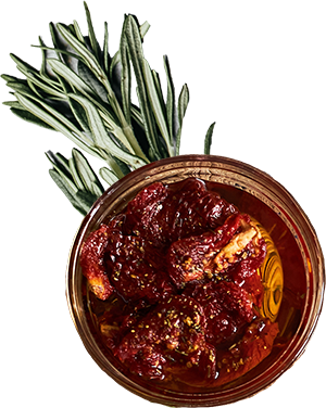 Schale mit Antipasti aus getrockneten Tomaten in Öl, dekoriert mit frischem Rosmarin.