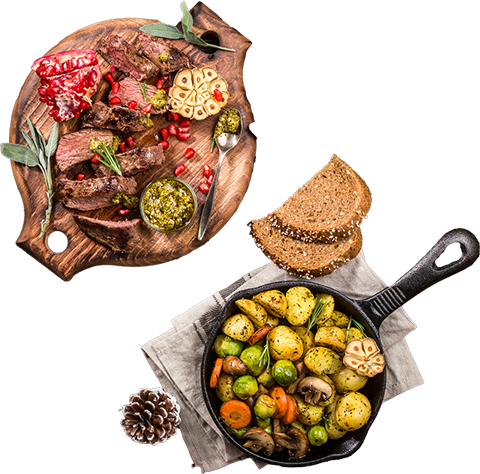 Festlicher Braten mit Granatapfel, Ofengemüse, Pesto und Brot auf rustikalem Holztisch.