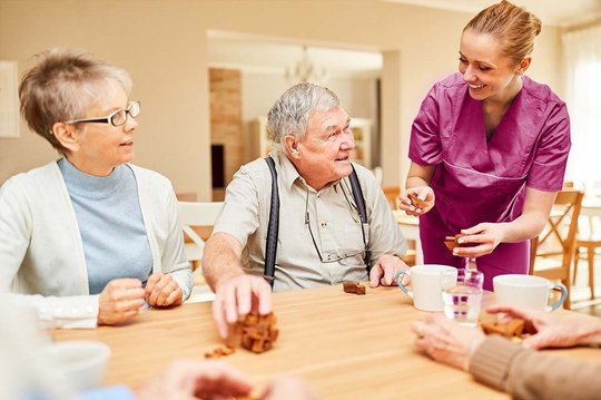 Senioren unterhalten sich mit einer Fachkraft der Pflege über Verpflegungsempfehlungen für ihre Ernährung