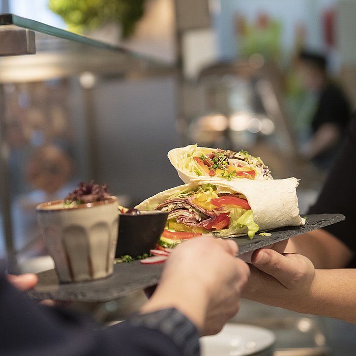 Ausgabe von frischen Wraps mit Gemüse für die Mitarbeiter