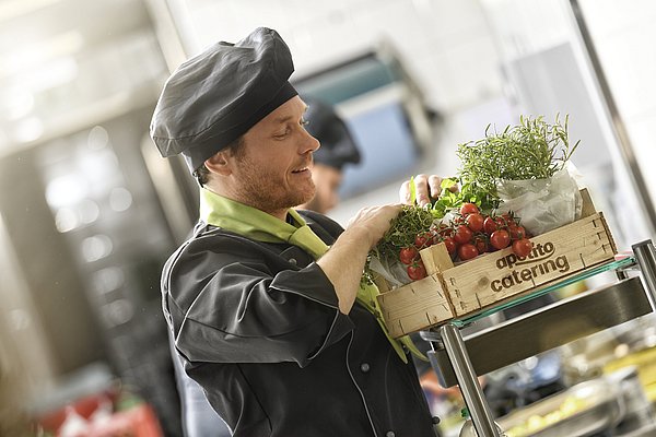 Holzkiste gefüllt mit frischen Tomaten aus der Region und leckeren Kräutern mit dem Schriftzug apetito catering