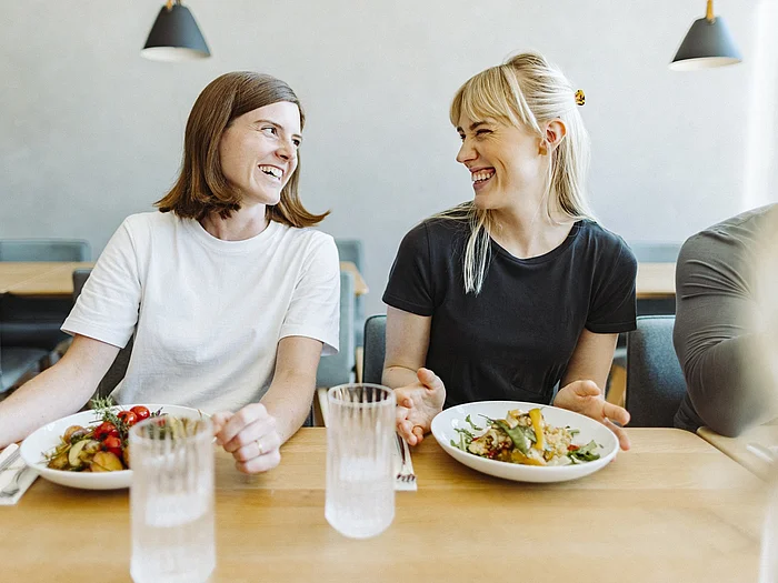 Glückliche Mitarbeiter genießen nachhaltiges Essen in der Mittagspause