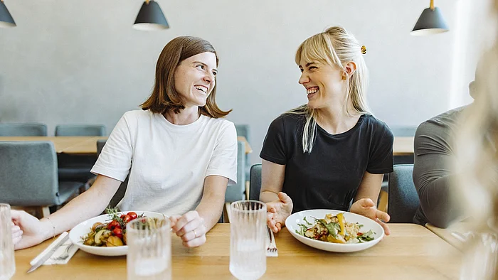 Glückliche Mitarbeiter genießen nachhaltiges Essen in der Mittagspause