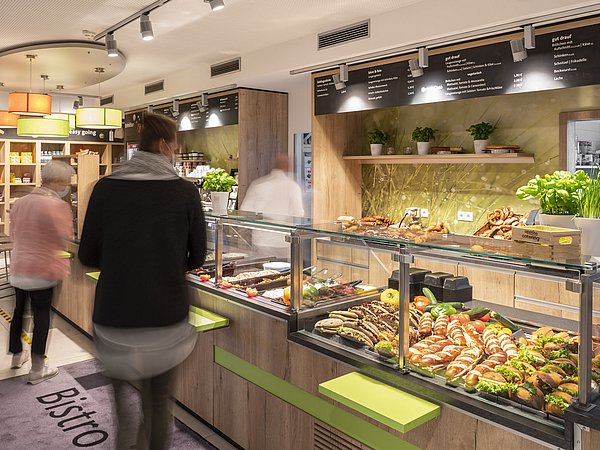 Mitarbeiter laufen durch die Ausgabe der Betriebsgastronomie