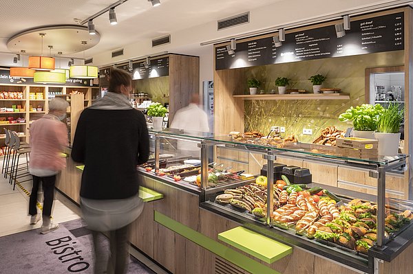 Mitarbeiter laufen durch die Ausgabe der Betriebsgastronomie